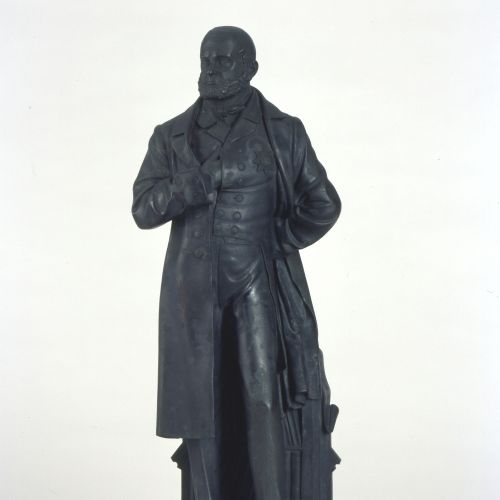 Die Plastik von Carl Dopmeyer zeigt Carl Ernst von Malortie (1804-1887), den Oberhofmarschall und königlichen Minister unter König Ernst August und Georg V. Malortie ist stehend vor einem Bücherregal dargestellt.