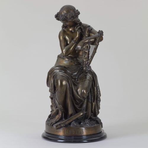 Wilhelm Engelhards Plastik zeigt die Lorelei als Halbakt auf einem Felsen sitzend mit Lyra. Sie stützt sich mit dem linken Arm auf ihr Instrument und greift mit der rechten Hand in ihr langes Haar, das ein Blumenkranz ziert.