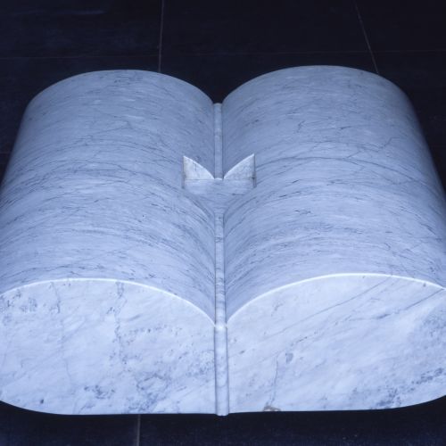 Es handelt sich um eine zweiteilige Skulptur von Peter H. van de Locht aus Carrara-Marmor. Der Titel des Ensembles was sein doch muß, dringt Körper ein in Körper geht zurück auf den Dichter Danthe Aligheri.